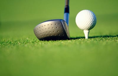 Golf club and ball on the grass
